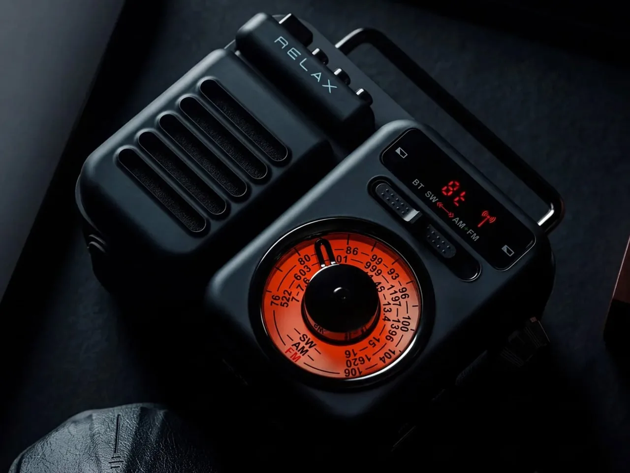 The RetroWave radio, a compact black unit with an orange analog tuning dial and a small display